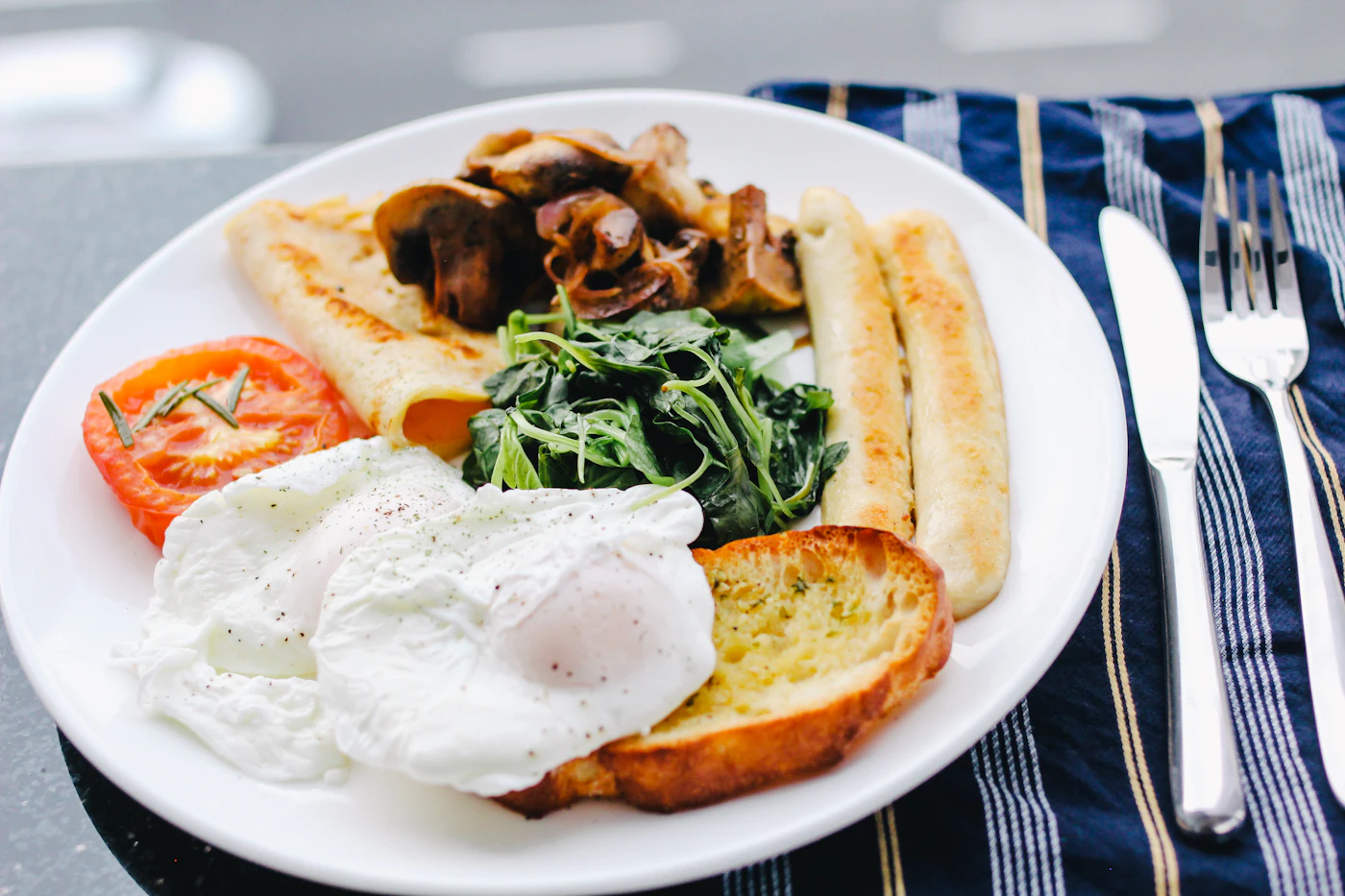 Plato de brunch con huevo pochado, verdes frescos y tostadas de masa madre